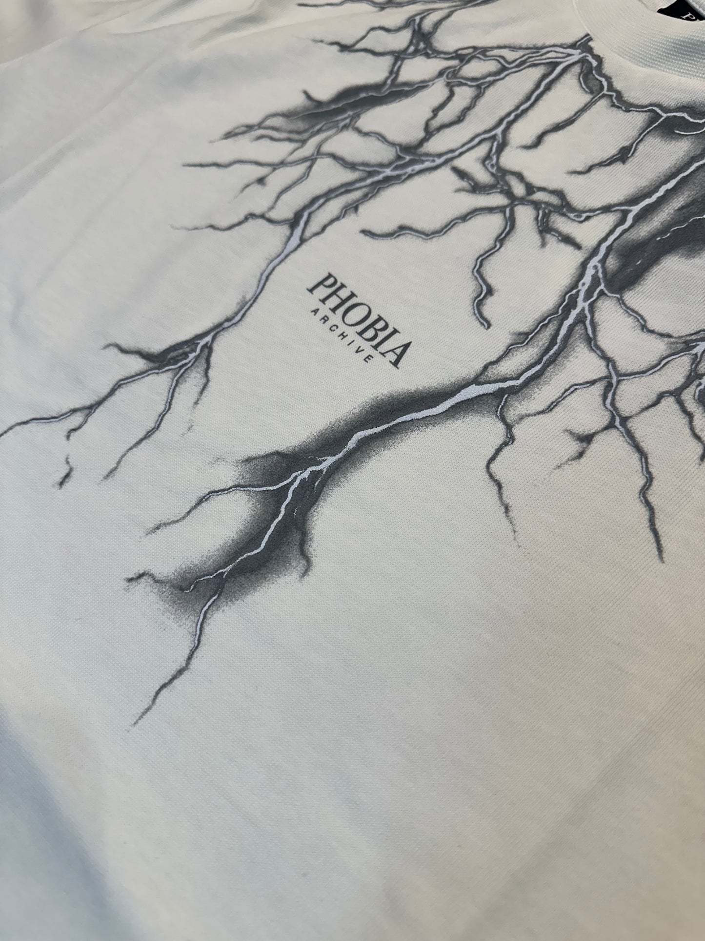 WHITE T-SHIRT WITH FRONT AND WHITE REFLECTIVE LIGHTNING