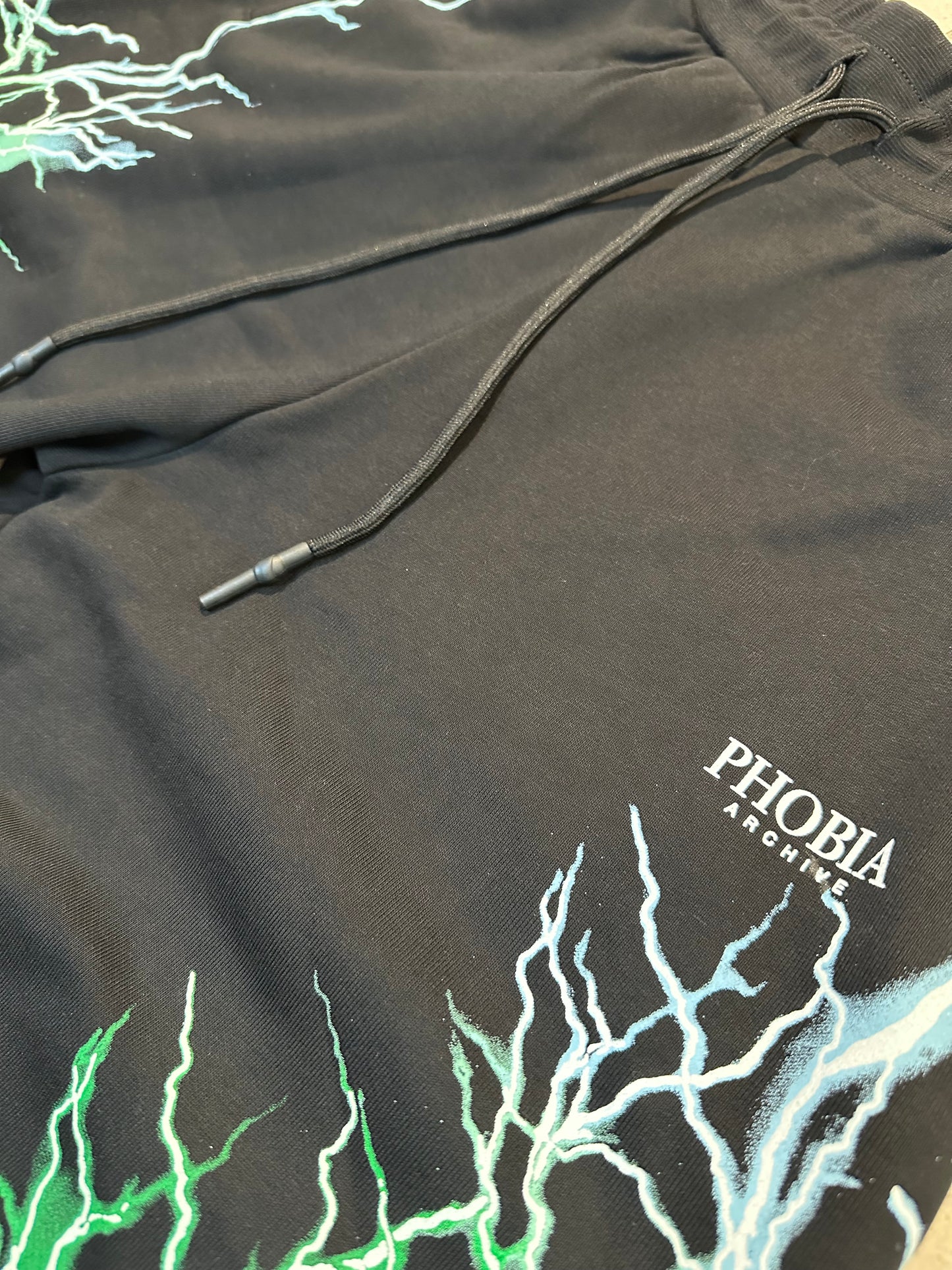 BLACK SHORTS WITH GREEN AND BLUE LIGHTNING PRINT AND LOGO PRINT